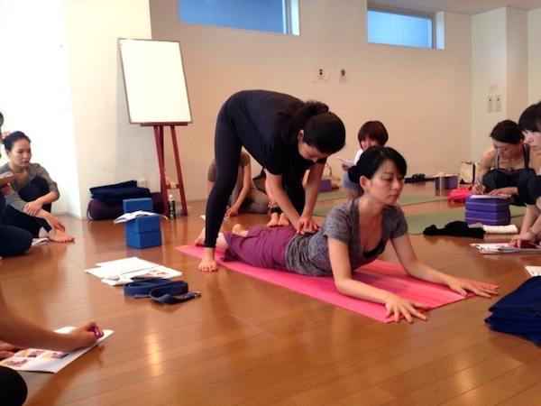 Kumiko Mack adjusting backbend pose at 500 hour Teacher Training Course at Be Yoga Japan, Hiroo, Tokyo